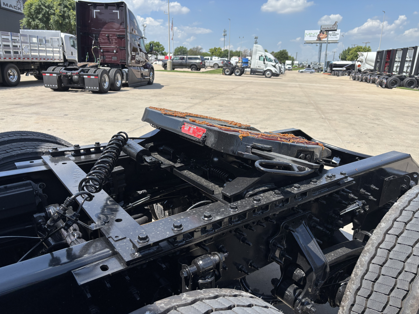 Volvo VNL64T860 chassis showing fifth wheel and frame components with trailer connections and tire in foreground.