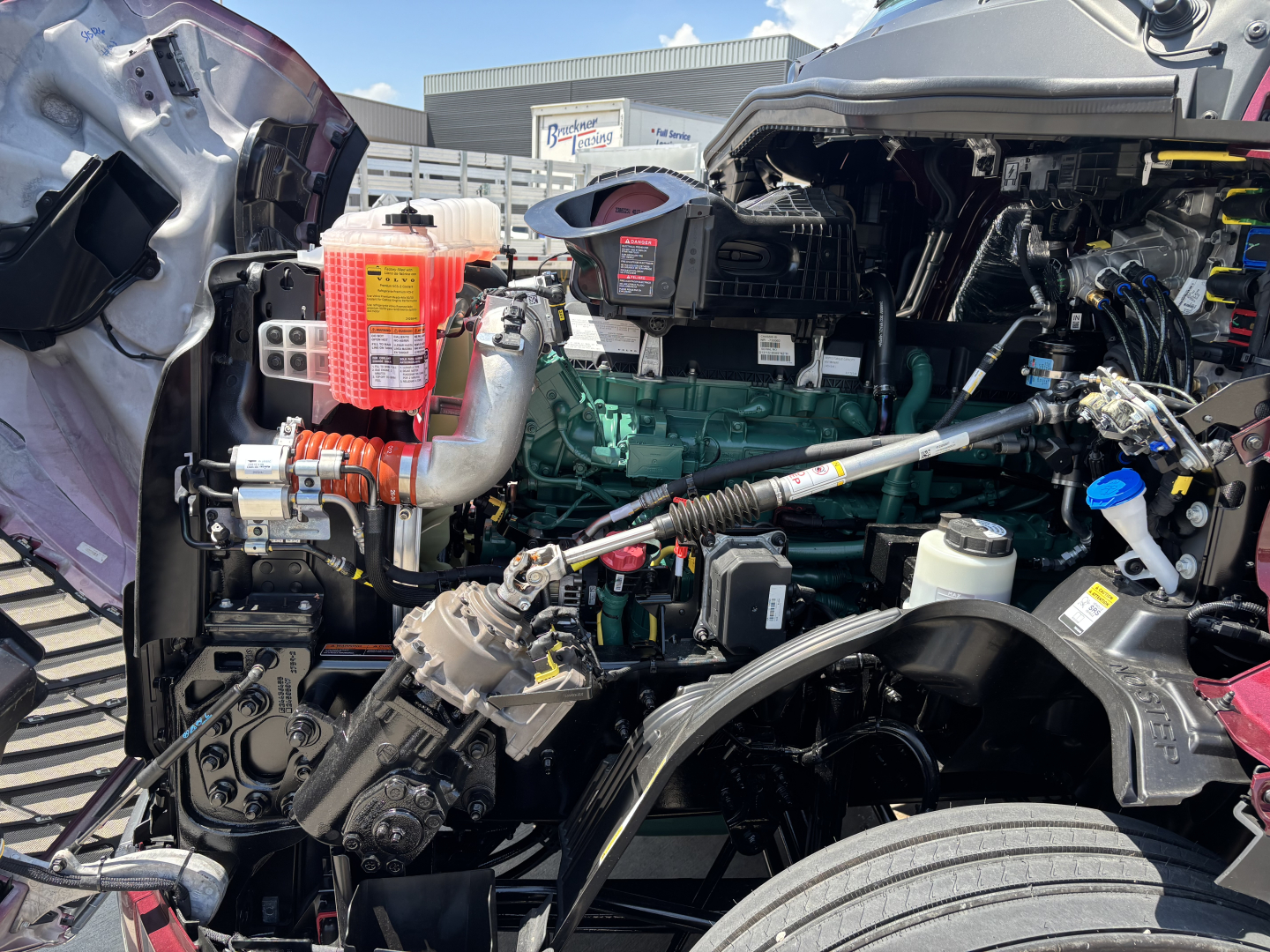 Volvo VNL64T860 engine bay showing diesel engine, coolant reservoir, turbocharger, wiring harnesses, and air intake components.