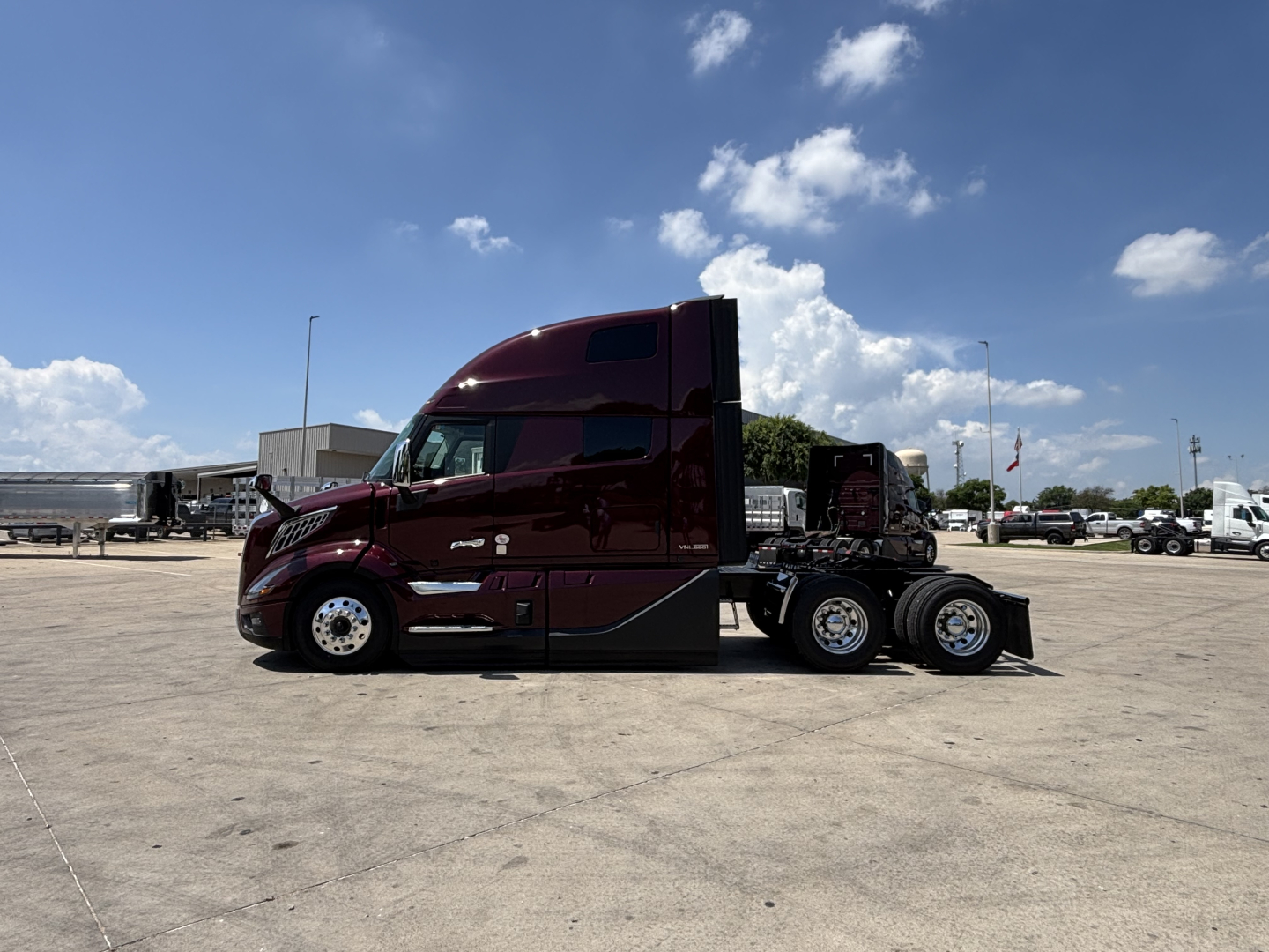 Volvo VNL64T860 sleeper cab tractor in burgundy, side profile view, with dual rear axles and chrome wheels.