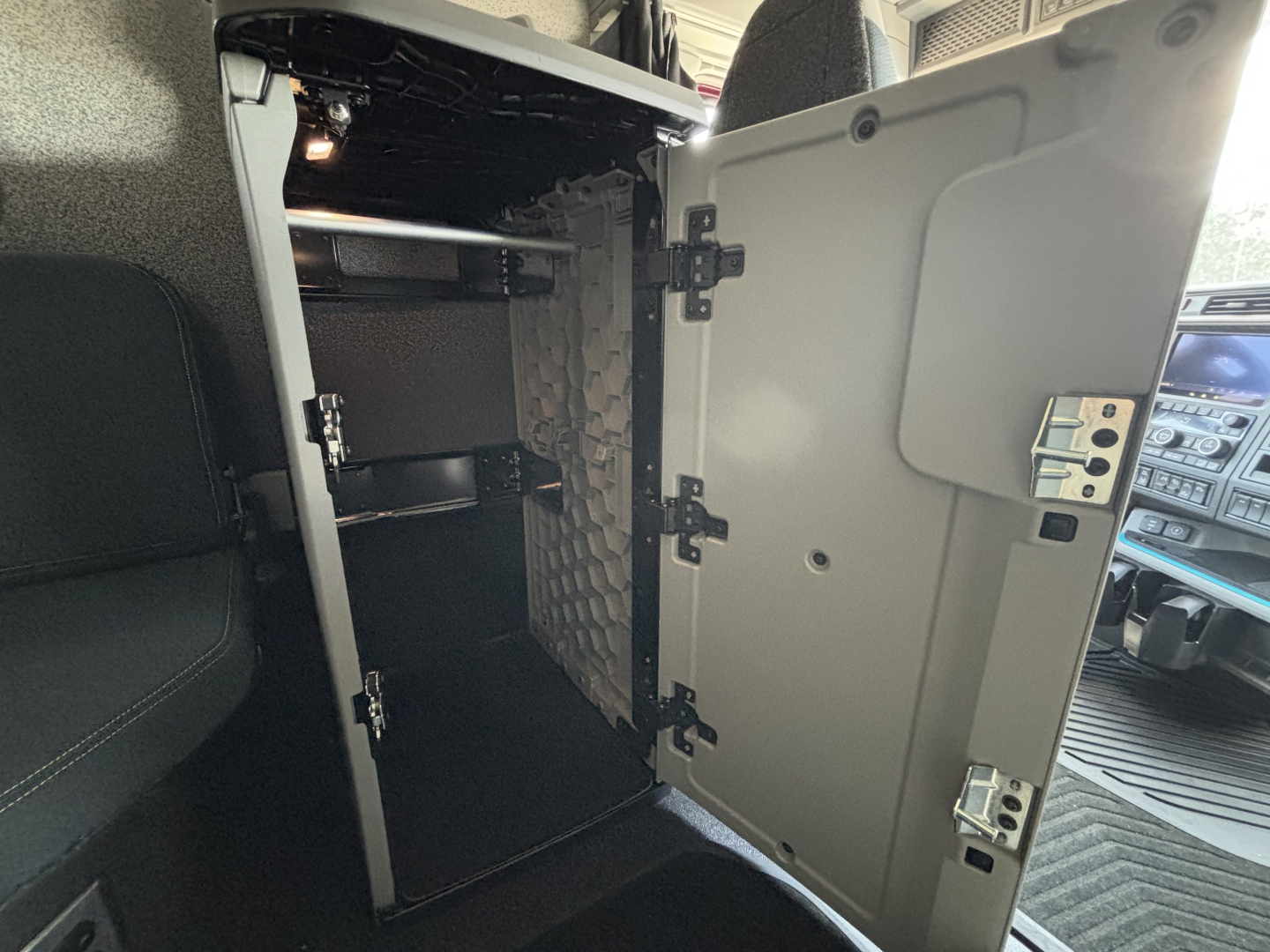 Volvo VNL64T860 cab interior showing open storage cabinet with shelves and small latch hardware.
