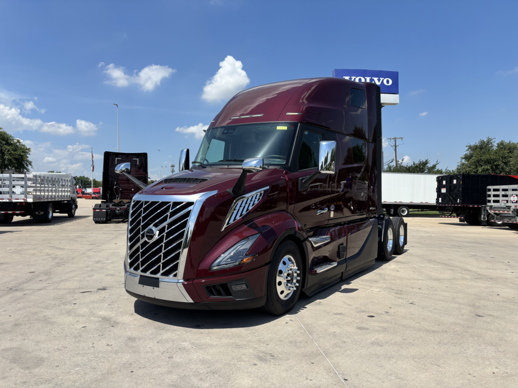 Volvo VNL64T860 sleeper tractor in burgundy, front-left view showing chrome grille and Volvo badge.