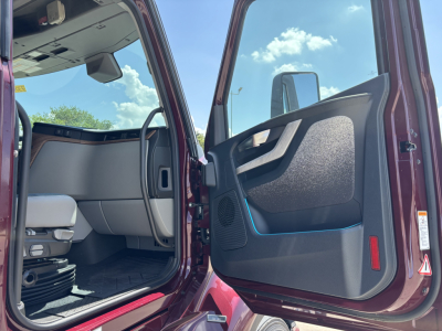 Cab interior of a Volvo VNL64T860 truck with open driver door showing dashboard, seat, and door panel. Text not visible due to image scope.