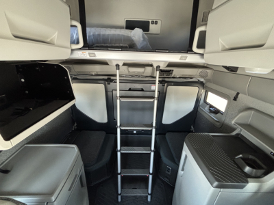 Volvo VNL64T860 cab interior view with ladder to sleeper, overhead storage, and kitchen counter, truck interior