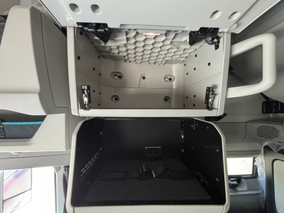 Volvo VNL64T860 cab interior showing overhead storage compartments and empty lower bunk storage bin.