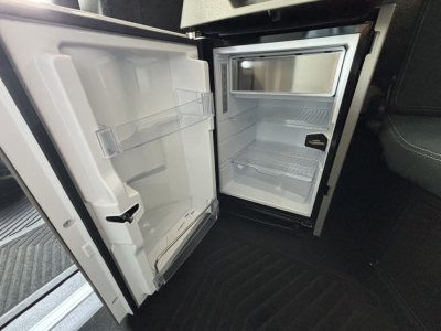 Volvo VNL64T860 truck interior showing open compact fridge/freezer and empty shelves inside cab area fridge door and small freezer compartment