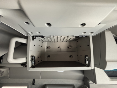 Volvo VNL64T860 cab interior showing open overhead bunk area and storage drawer in center console.