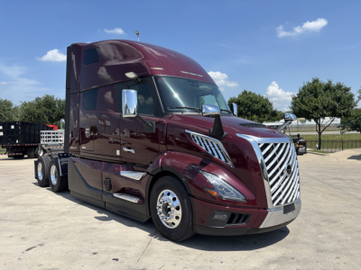 Volvo VNL64T860 truck in maroon showing chrome grille, chrome mirrors, and stacked sleeper cab. No visible text on components.