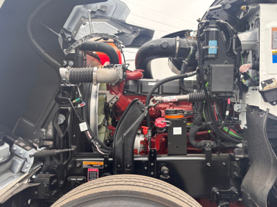 Mack PI64 engine bay view showing red engine components, hoses, wiring, and air intake with various labels and connectors.
