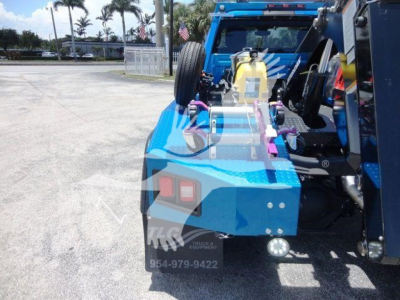 Rear view of a blue Ram 4500 winch-equipped truck showing tail lights, spare tire, and winch equipment mounted in bed.