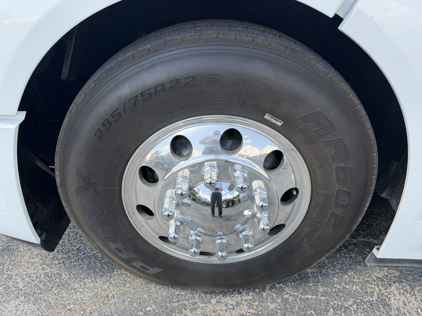 Wheel and tire close-up on a Volvo VNL truck showing tire markings 295/75R22.5 and chrome lug nuts.