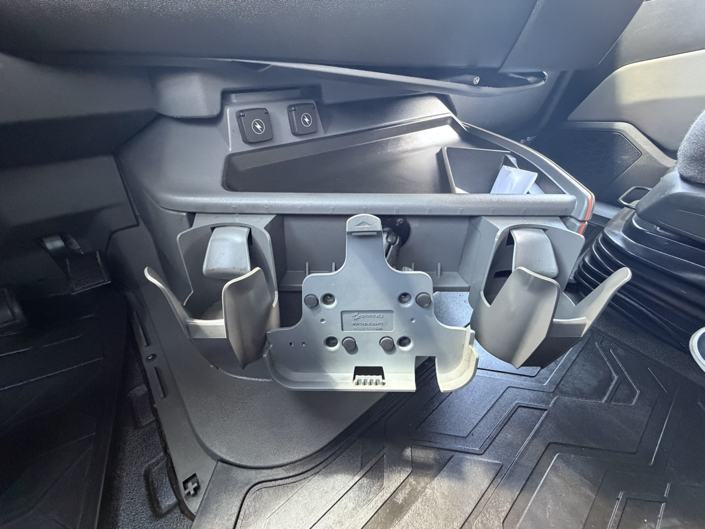Volvo VNL64T740 cab interior showing driver's seat base with mounting brackets and controls, including two switches and storage pocket