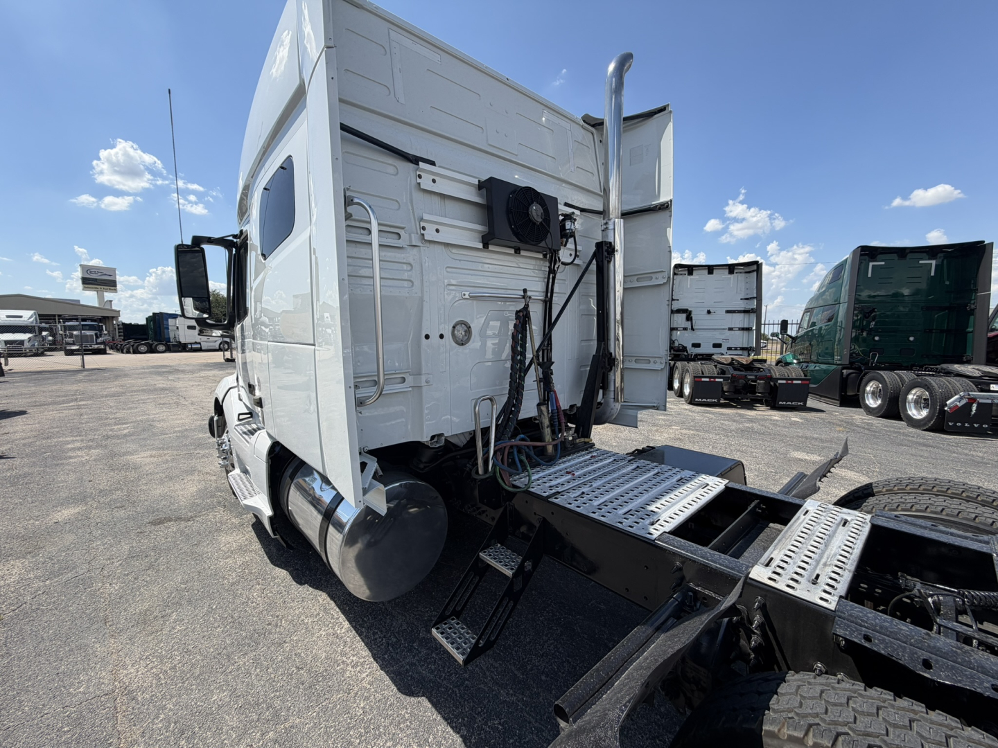 Volvo VNL64T740 sleeper tractor rear view showing side air intake and steps, tiedown lugs, and chassis with cab access panels.