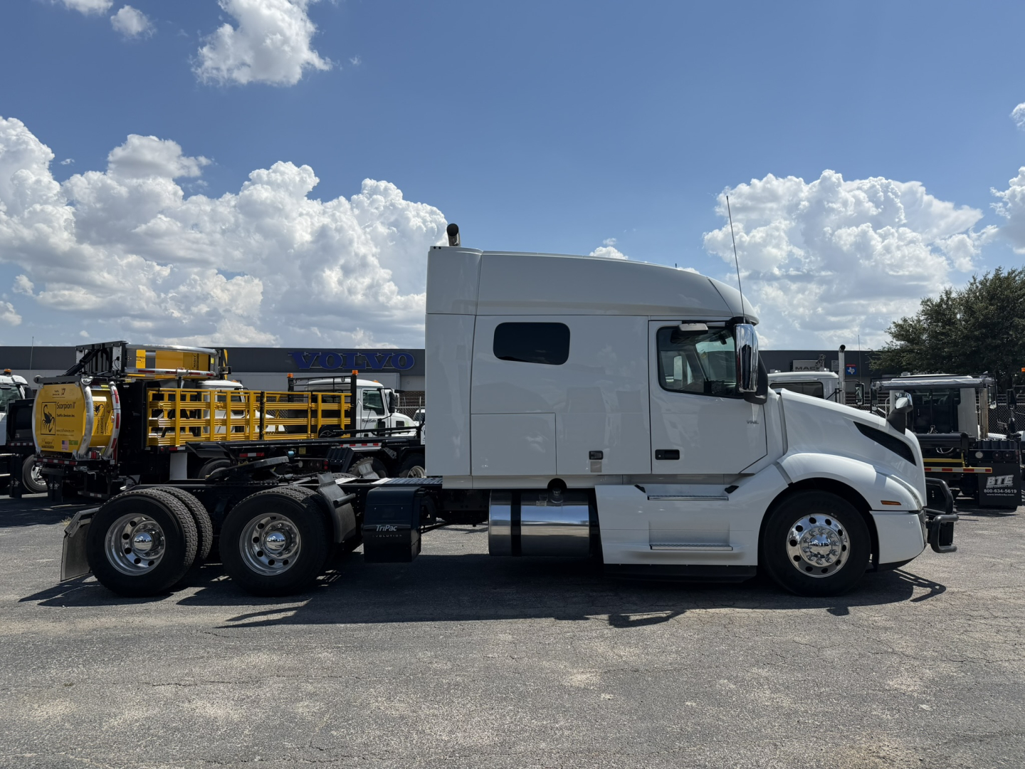 Volvo VNL64T740 truck side view showing sleeper cab, two rear axles, and chrome wheels.
