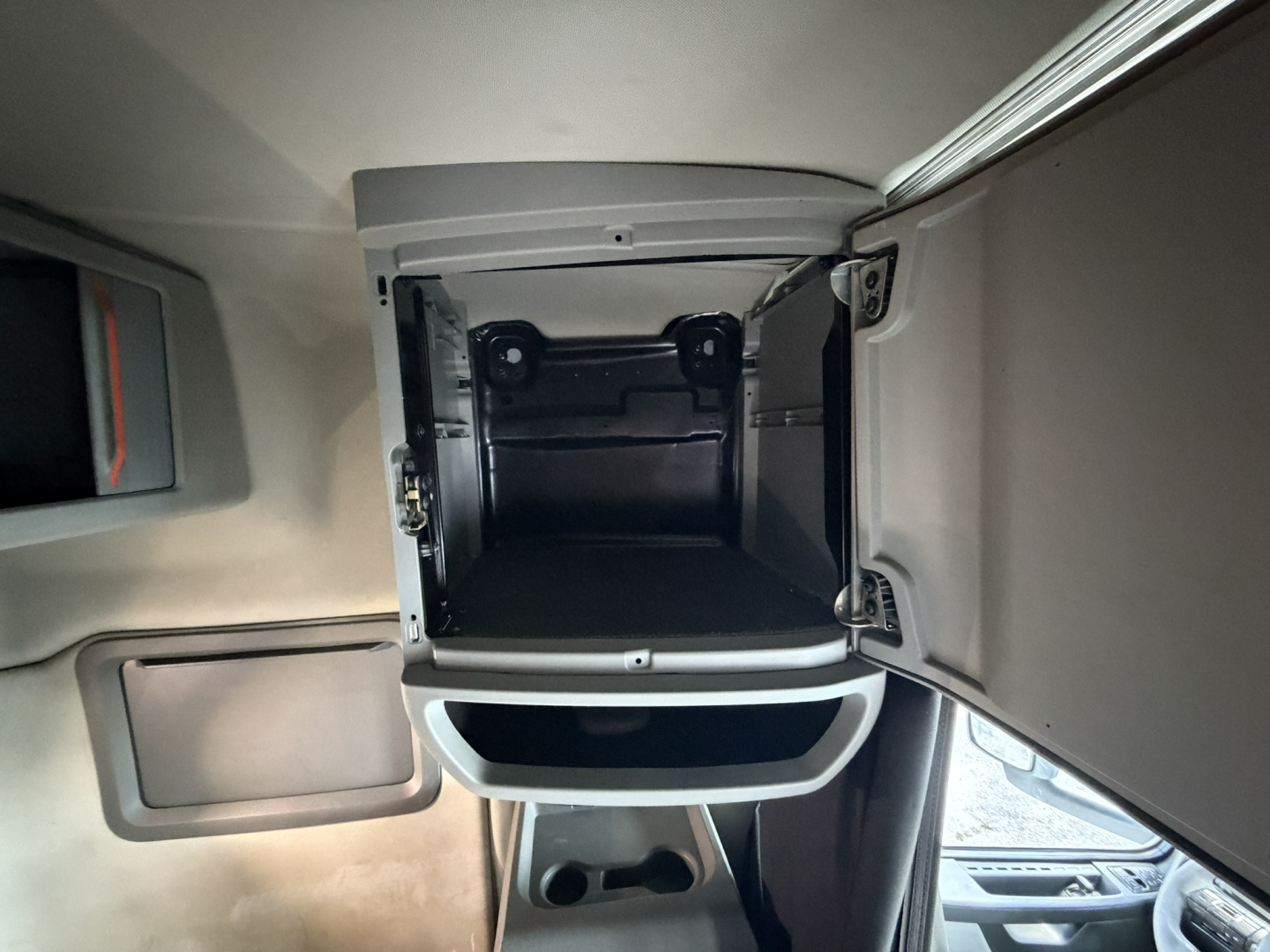 Volvo truck sleeper cab storage compartment open showing interior shelves and latch