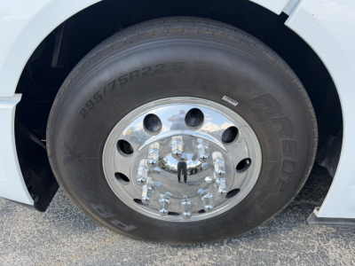 Wheel and tire close-up on a Volvo VNL truck showing tire markings 295/75R22.5 and chrome lug nuts.
