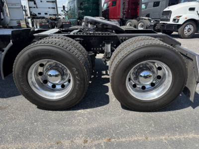 Volvo VNL64T740 tractor truck chassis showing dual rear axles and twin wheels with chrome hubs.