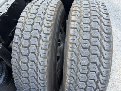 Volvo VNL truck axle with dual tires showing tread pattern and inner wheel; close-up of tire treads and rims.