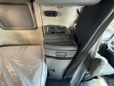 Volvo VNL64T740 sleeper cab interior showing center console and driver seat area with windows and storage compartments.
