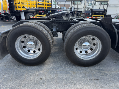  Volvo VNL truck rear dual wheels showing chrome hubcaps and tire treads with frame and fifth wheel visible.