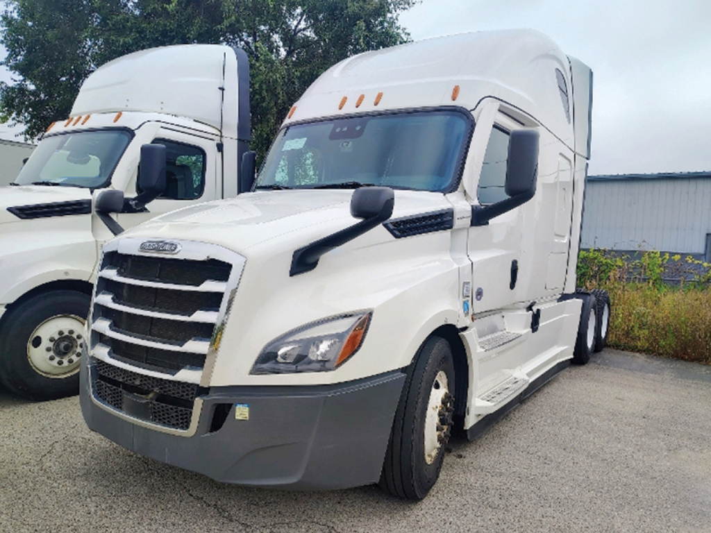 Truck cab exterior: 2022 Freightliner Cascadia126 sleeper tractor in white with black mirrors and grille, front view showing headlights and bumper.