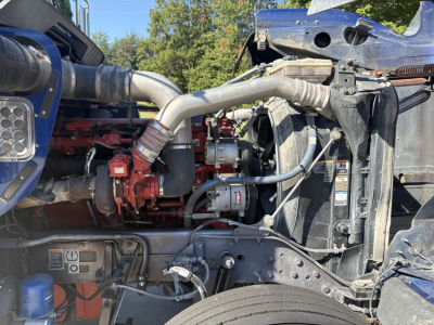 Kenworth W900L engine bay showing turbocharger piping and coolant hoses in a diesel truck, front grille removed