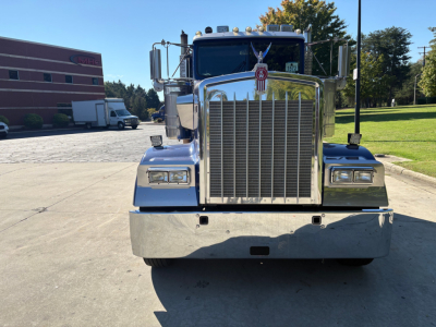 Kenworth W900L front view showing large chrome grille, rectangular headlights, and chrome bumper.