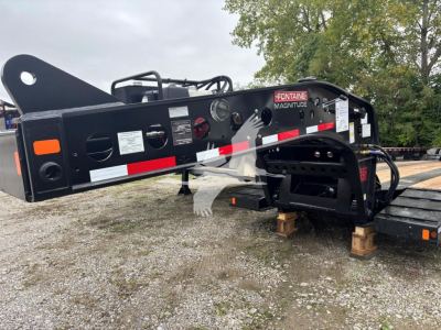 Fontaine 55MX lowboy trailer neck showing Fontaine Magnitude branding and label decals, hydraulic hoses, and structural frame with reflective tape.