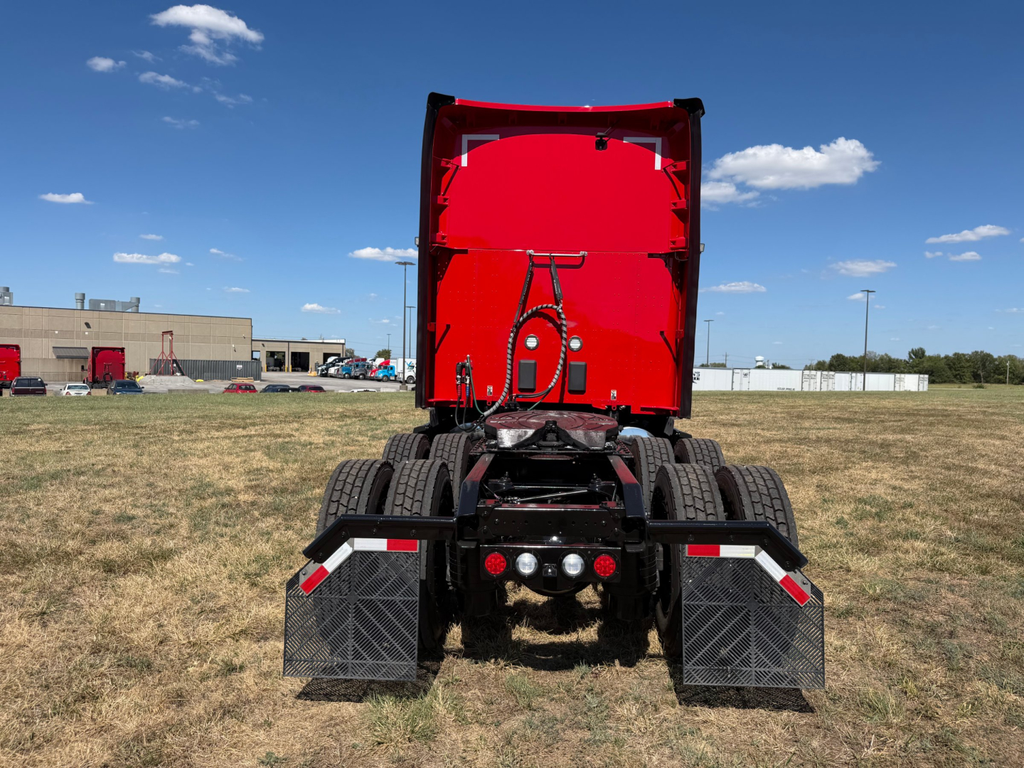 Kenworth semi-truck rear view showing dual rear axles and mud flaps.