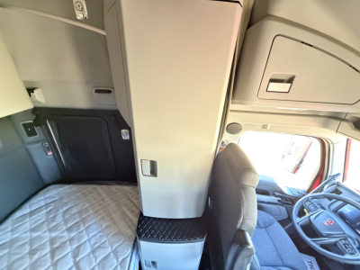 Kenworth T680 cabin interior with sleeper area and center console, driver seat, and dashboard visible.