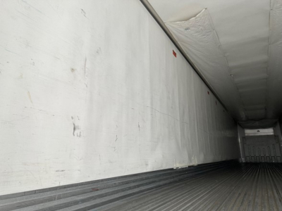 Trailer interior with insulated white walls and ribbed black floor; empty cargo space.