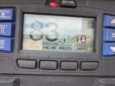 Truck trailer interior display showing engine hours 16654 and setpoint 83.1°F on digital screen with surrounding blue buttons.