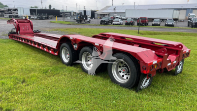 Kenworth Fontaine 55LCC lowboy trailer showing red steel frame and triple-axle configuration with alloy wheels.