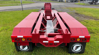 Red Fontaine lowboy trailer rear view showing deck and undercarriage with taillights and ramps; Fontaine branding on mudflaps.