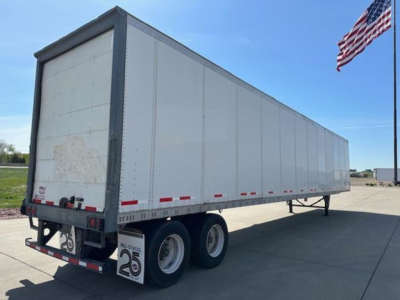 Trailer side view showing a 2016 Wabash van trailer with a white exterior, dual rear axles, and red reflectors along the lower edge.