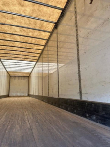 Trailer interior showing long empty dry cargo area with wooden floor and metal side rails in a Wabash van trailer