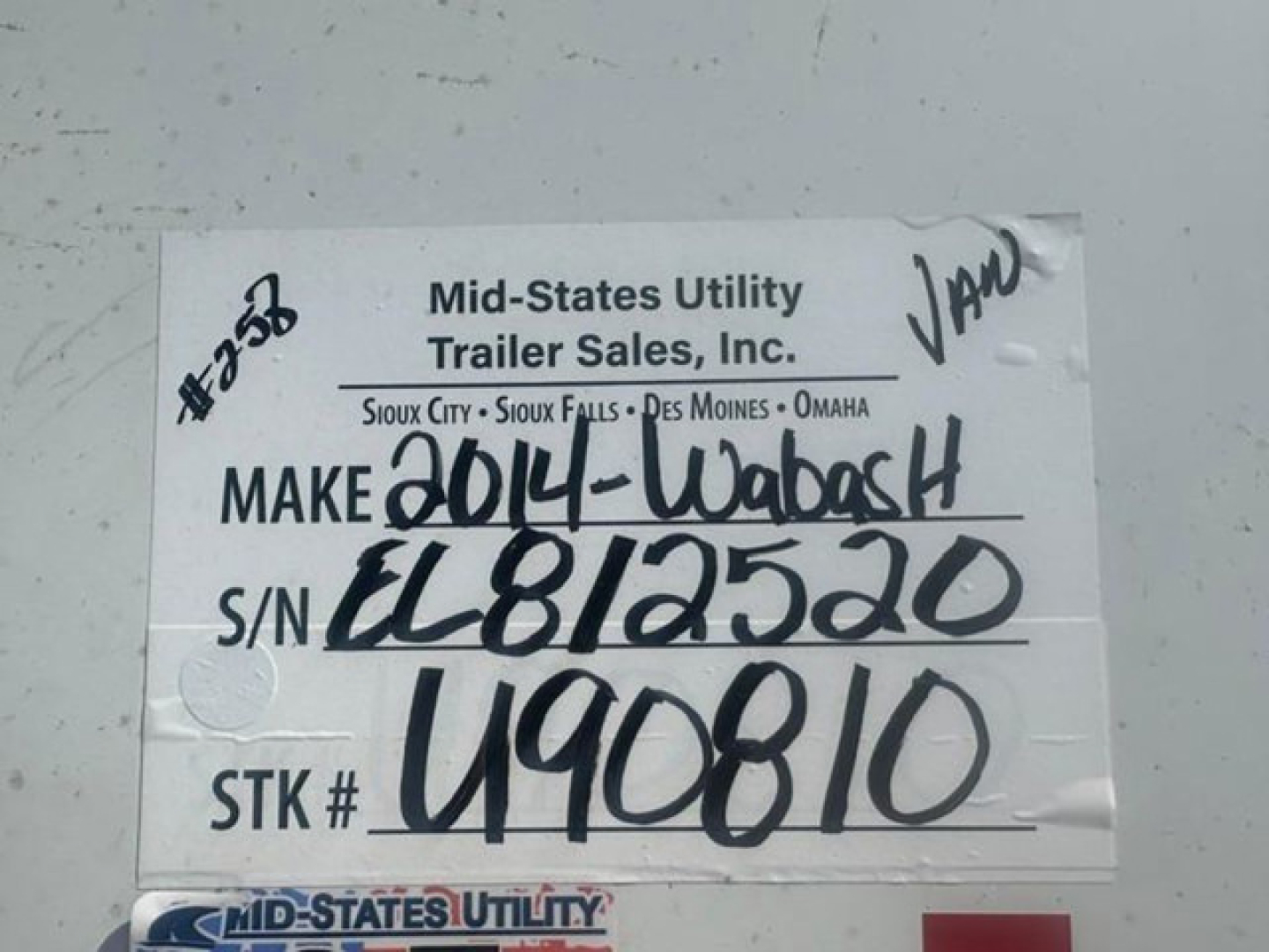 Tag on trailer showing Mid-States Utility Trailer Sales label with handwritten year 2014-Wabash, S/N EL812520, STK # U90810.