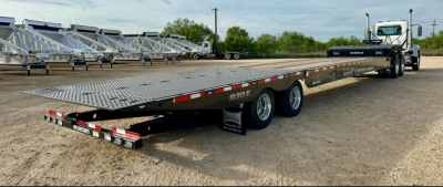 Flatbed trailer showing low-profile metal deck with multiple axles and rear lights; side shows model number 930E and reflective striping.