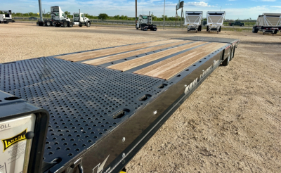Landoll 930E-51-15 trailer deck view showing perforated steel gooseneck and wooden planks with wheel wells along side.