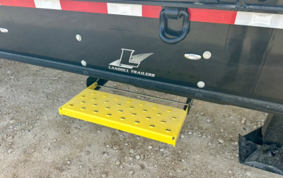 Trailer rear showing Landoll Trailers logo and yellow perforated step beneath tailgate.