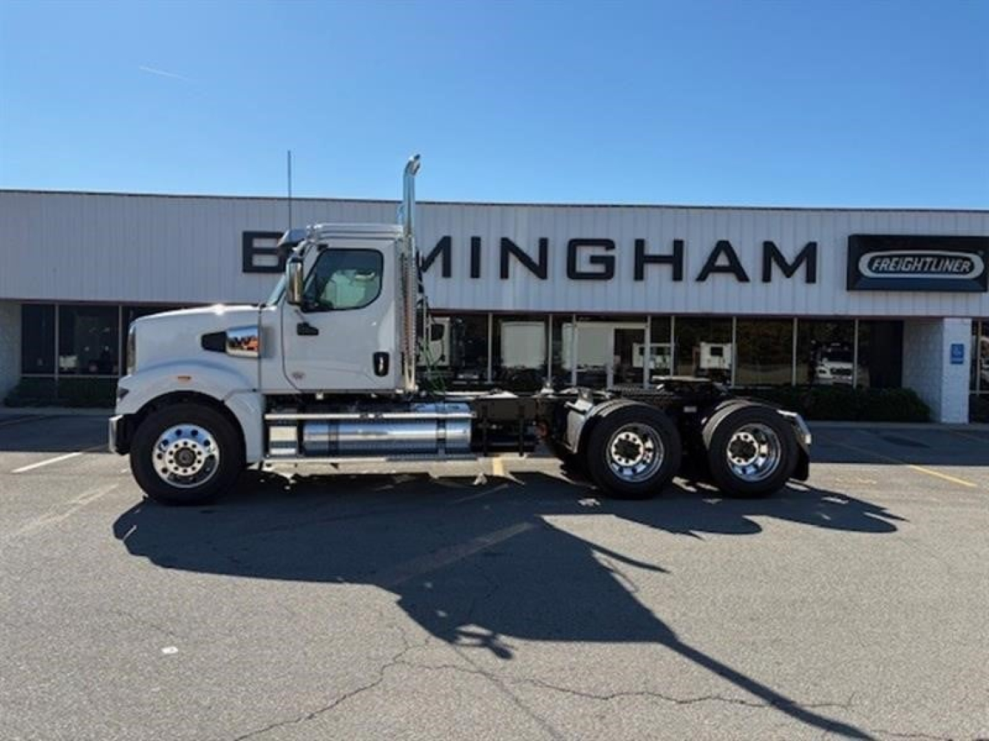 Western Star 49X truck side view in dealership lot showing factory cab and chassis with dual rear axles.