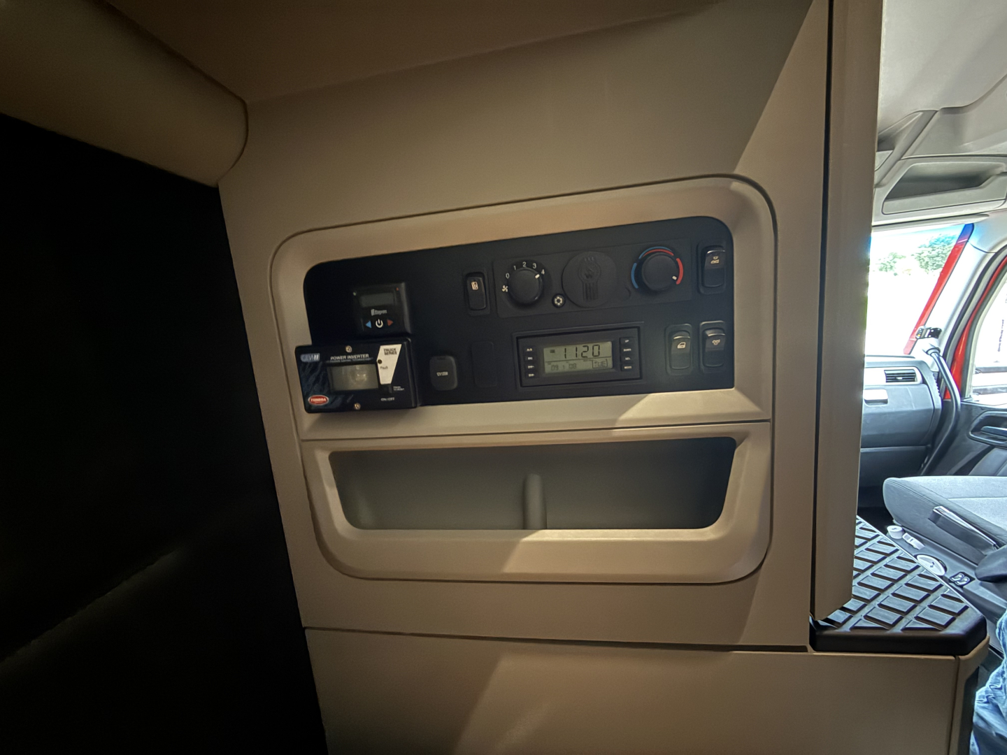 Kenworth T680 cab interior panel showing control switches and a digital clock display in the dash area.