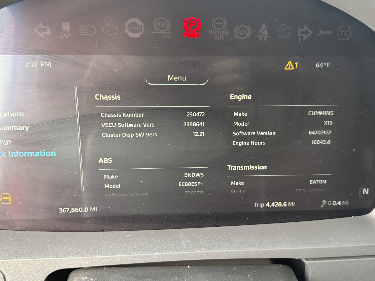 Truck dashboard display showing chassis and engine information with ECU software version, engine hours, and transmission data.
