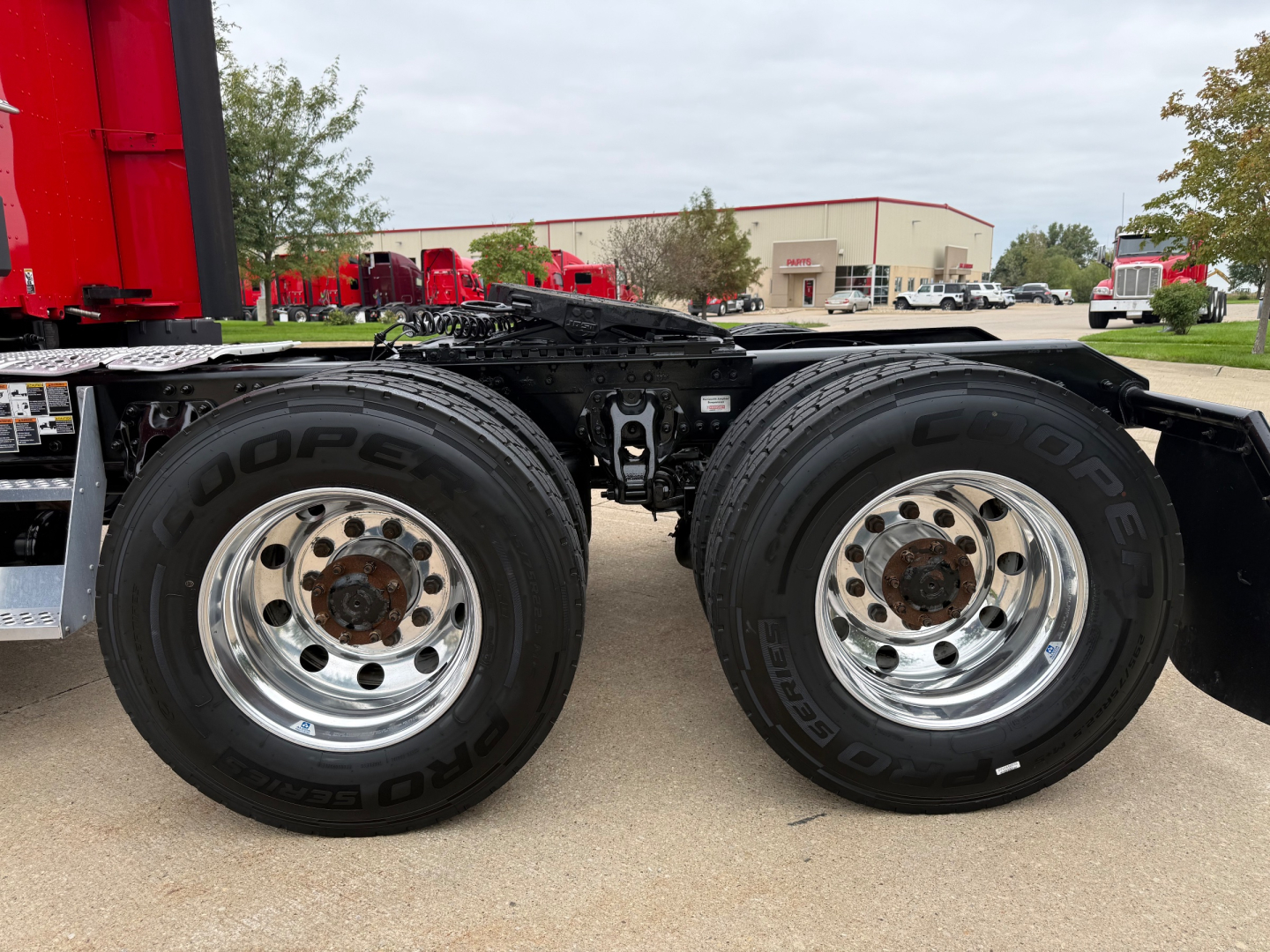 Kenworth T680 rear wheel assembly showing dual rear tires and chrome rims with black chassis components.