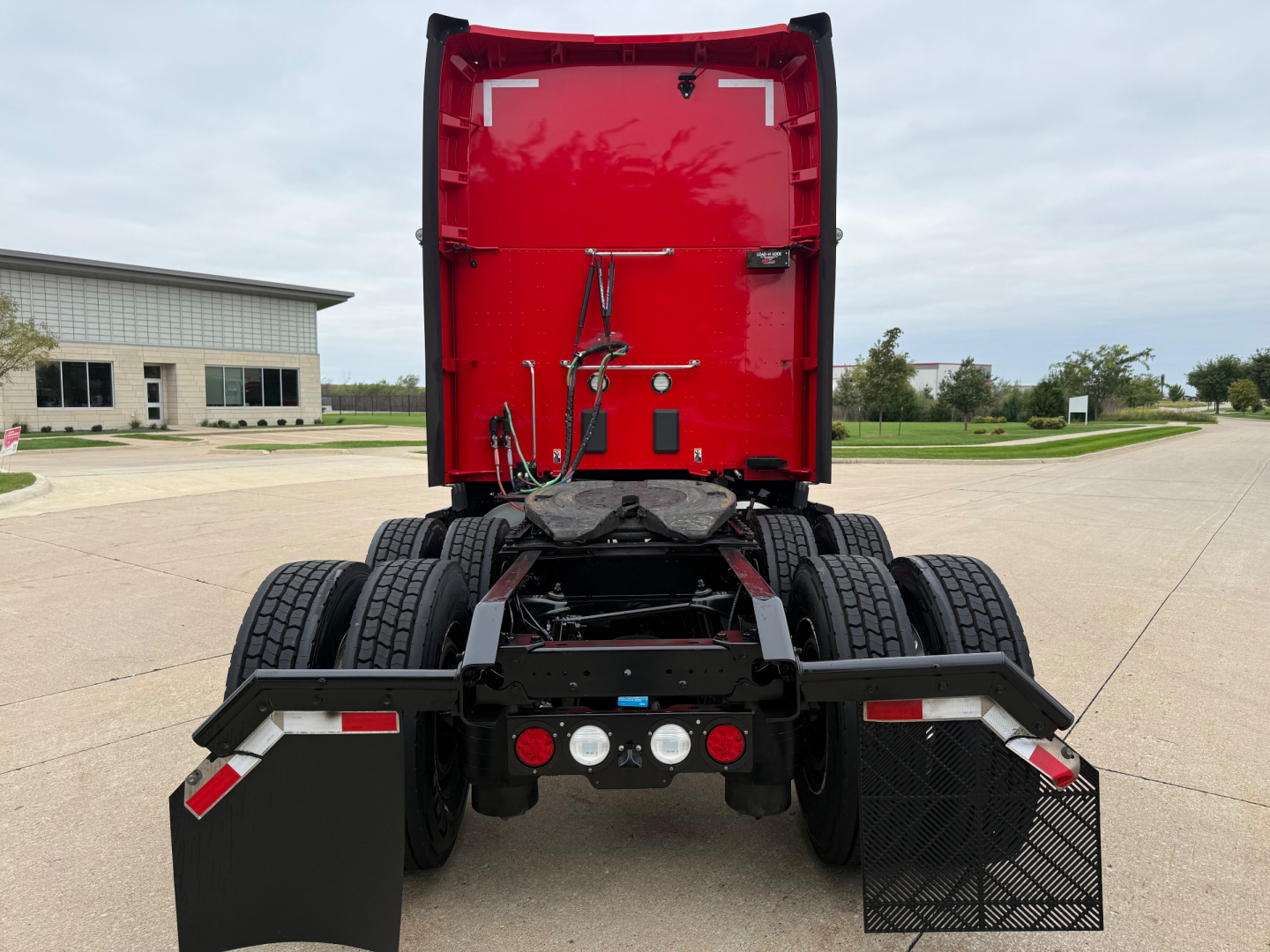 Kenworth T680 rear view showing chassis and fifth wheel area with mudflaps and linkages