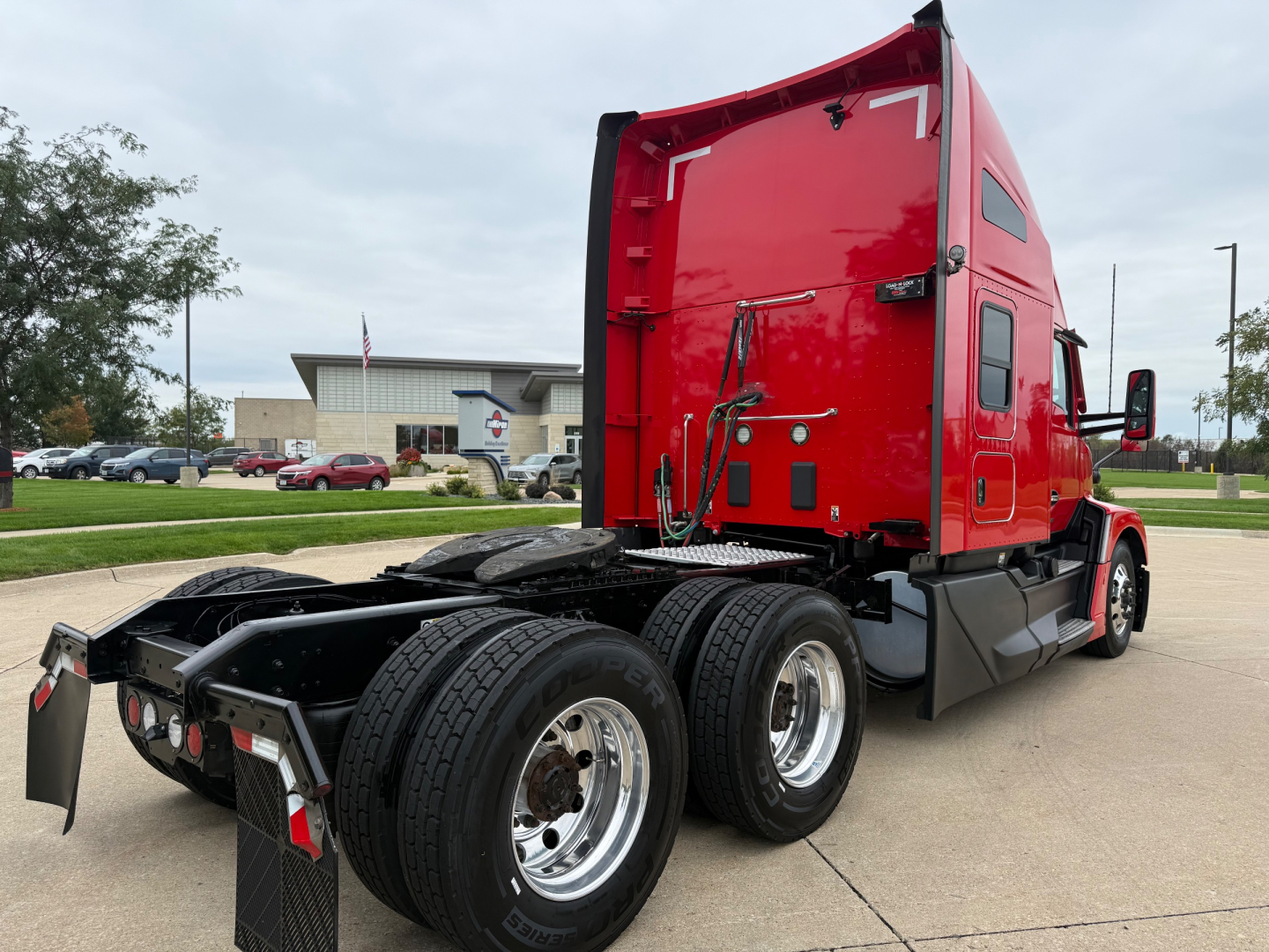 Kenworth T680 tractor rear view showing fifth wheel area and dual rear axles with red sleeper cab.