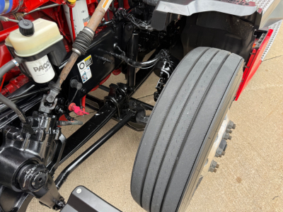 Kenworth T680 engine bay and front suspension showing air filter reservoir and dual rear tandem wheel area.