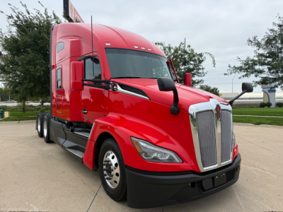 Kenworth T680 in red, front three-quarters view showing chrome grille, headlights, and side mirrors.