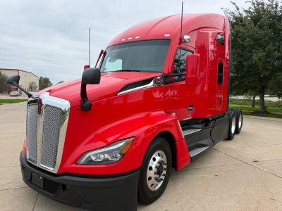 Kenworth T680 truck in red, front three-quarter view showing grille, headlights, and side mirror with sleeper cab.