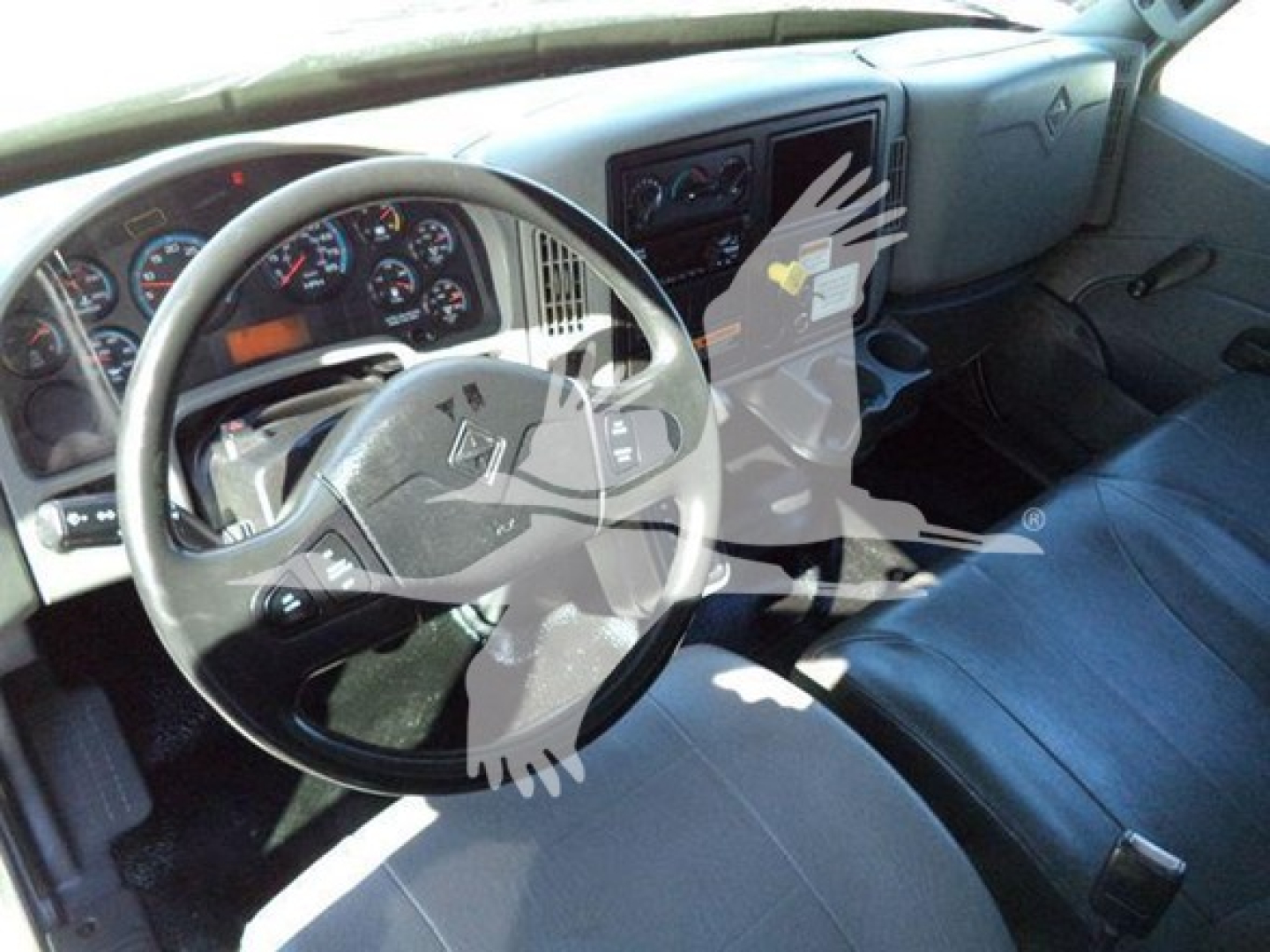 Dashboard and driver seat of a 2019 International Durastar 4300 with steering wheel, gauge cluster, and center console visible.