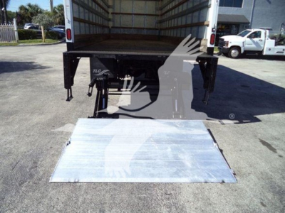 Truck with a rear aluminum ramp lowered, International Durastar 4300 box truck, cargo area visible, hydraulic lift legs.